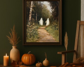 Puede incluir: Una pintura enmarcada muestra dos figuras de fantasmas blancos caminando por un sendero en un bosque. La pintura se exhibe sobre una repisa con una vela encendida, una calabaza y decoraciones otoñales. La paleta de colores incluye verdes, marrones y naranjas.
