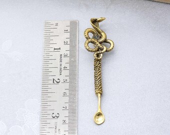 May include: A gold-toned metal spoon with a snake design on the handle. The spoon is about 2 inches long and has a rounded bowl. The snake is coiled around the handle and has a detailed design.