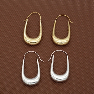 May include: Four hoop earrings, two gold and two silver, with a curved, u-shaped design.
