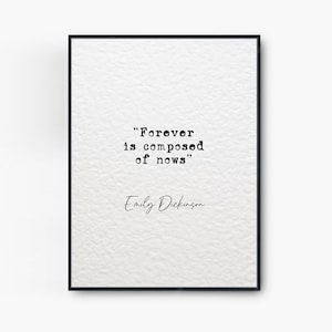 May include: Black and white typography print with the quote "Forever is composed of nows" by Emily Dickinson. The quote is framed in a black frame.