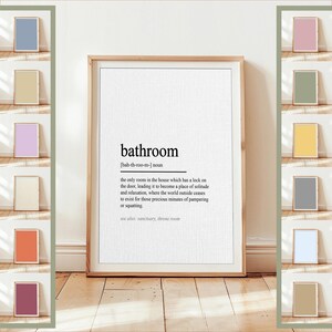 Peut inclure: Une impression encadrée avec la définition de "salle de bain" en texte noir sur fond blanc. La définition comprend la prononciation et une description de la pièce. Diverses impressions carrées colorées sont affichées.
