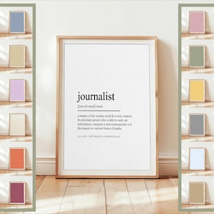 May include: A framed print with the definition of "journalist" in black text on a white background. The definition includes the pronunciation and a description of the profession. The frame is a light brown color.