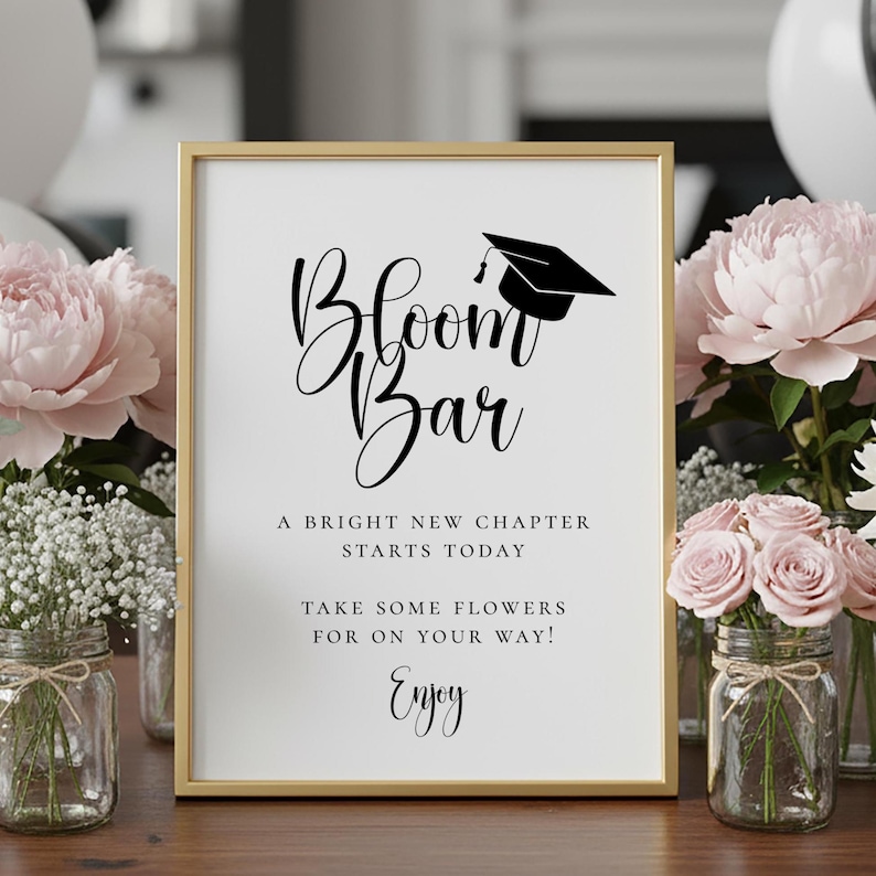 Op de afbeelding: Een ingelijst bord met de woorden "Bloom Bar" in elegant schrift, bekroond met een illustratie van een afstudeerpet. Het bord bevat de zinnen "A Bright New Chapter Starts Today" en "Take Some Flowers For On Your Way! Enjoy!"