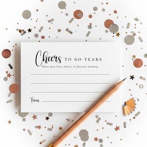 Puede incluir: Una tarjeta blanca con el texto "Cheers to 60 Years" y espacio para escribir un mensaje. Un lápiz de madera descansa sobre la tarjeta, rodeado de confeti en forma de estrellas plateadas, cobrizas y negras.