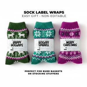 May include: Three pairs of holiday socks in green, teal, and purple, each with a white label. The green socks have a reindeer pattern, the teal socks have snowflakes, and the purple socks have a snowflake pattern. The labels read "Happy Holidays", "Holiday Sparkle", and "Merry Christmas".