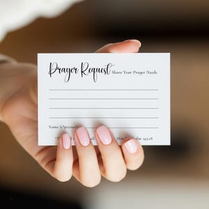 Pode incluir: Um cartão branco com as palavras "Prayer Request" em escrita elegante. O cartão inclui linhas para escrever e o texto "Share Your Prayer Needs" e "Name (Optional)". Um versículo bíblico também está impresso no cartão.