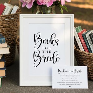 Puede incluir: Un letrero enmarcado blanco con el texto "Books for the Bride" en una elegante escritura. La imagen incluye una peque&ntilde;a tarjeta con texto, cestas de libros y flores rosas en un tarro de cristal, lo que sugiere un tema de boda.