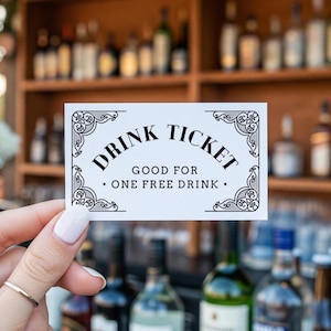 May include: A white drink ticket with black text and decorative corner flourishes. The ticket reads "DRINK TICKET GOOD FOR ONE FREE DRINK." The background features a bar with bottles of liquor.