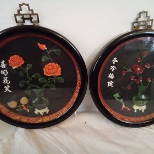 May include: Two round framed wall decorations with black backgrounds. The left frame features a jade green vase with orange flowers and the Chinese characters "幸福花笑". The right frame features a jade green vase with red flowers and the Chinese characters "寿有福禄".
