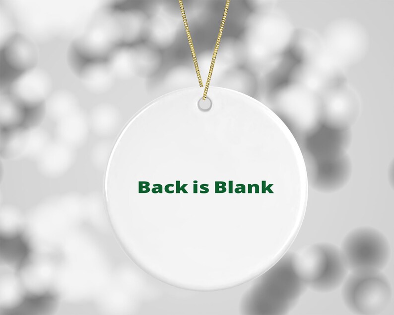 K&ouml;nnte beinhalten: Runder wei&szlig;er Keramik-Anh&auml;nger mit einer gr&uuml;nen Schnur zum Aufh&auml;ngen. Die Vorderseite des Anh&auml;ngers tr&auml;gt den Text "Back is Blank" in gr&uuml;n.