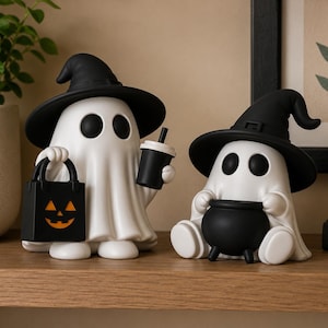 Op de afbeelding: Twee witte spookbeeldjes met zwarte heksenhoeden. Het staande spook houdt een zwarte tas met een oranje pompoengezicht en een zwarte beker vast. Het kleinere zittende spook houdt een zwarte ketel vast. Beide hebben zwarte ogen en gladde oppervlakken.