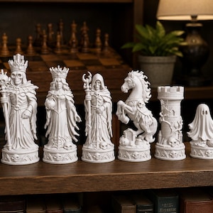 May include: A white chess set with themed pieces, including a skeleton king, queen, and other figures. The pieces are arranged on a wooden surface, with a chessboard and lamp in the background. The set has a gothic or fantasy theme.