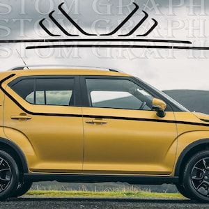 Op de afbeelding: Een mosterdgele hatchback auto met zwarte vinyl sticker graphics op de zijpanelen. De afbeeldingen bestaan uit een lange horizontale streep langs de deuren en drie schuine strepen op het achterste zijpaneel van de carrosserie.