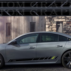 May include: A silver Peugeot 508 car with black and yellow accents. The car is parked in front of a wooden and stone building.