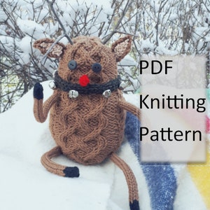 May include: Knitting pattern for a brown reindeer with a red nose and jingle bells around its neck. The reindeer is sitting in the snow. PDF Knitting Pattern.