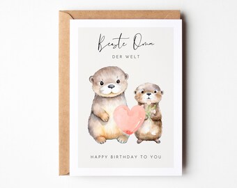 May include: A greeting card with two otters holding a pink heart. The card reads "Beste Oma der Welt" and "Happy Birthday to You".
