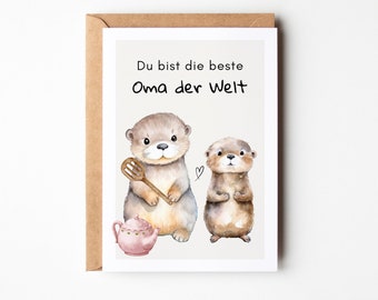May include: Greeting card with a watercolor illustration of two otters. One otter holds a wooden honey dipper, and a pink teapot is below. The text "Du bist die beste Oma der Welt" is at the top.