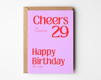 May include: A pink birthday card with the text "Cheers to forever 29 Happy Birthday to you" in red.