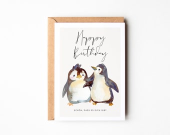 May include: A greeting card with a watercolor illustration of two penguins. The card reads "Happy Birthday" and "Schon, dass es dich gibt".