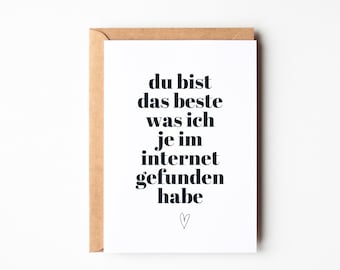 Op de afbeelding: Witte wenskaart met zwarte tekst: "du bist das beste was ich je im internet gefunden habe" en een klein hartje. De kaart zit in een bruine envelop.