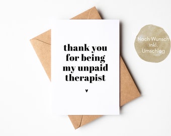 May include: White card with black text that reads "thank you for being my unpaid therapist" with a small heart symbol at the bottom. The card is on top of a brown envelope.