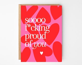 May include: A greeting card with a pink background and red heart shapes. The card features the text "sooooo f*cking proud of you" in white, with a small white heart at the bottom. The card has a brown paper envelope.