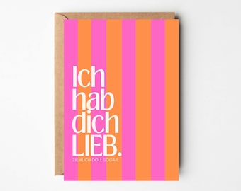 May include: Greeting card with a pink and orange striped design. The card features the German text "Ich hab dich lieb" in white, with the phrase "Ziemlich doll sogar" below. The card is in a brown envelope.