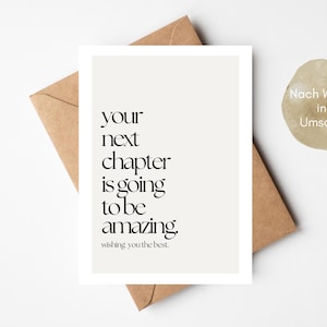 Könnte beinhalten: Eine Grußkarte mit der Aufschrift "your next chapter is going to be amazing" in schwarzem Text. Die Karte befindet sich auf einem beigen Hintergrund, mit einem braunen Umschlag dahinter. Ein runder Aufkleber mit deutschem Text ist ebenfalls vorhanden.