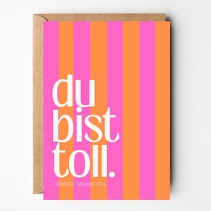 Op de afbeelding: Wenskaart met een verticaal gestreept patroon in roze en oranje. De kaart bevat de Duitse zin "du bist toll" in het wit, samen met de woorden "sooooo, sooooo toll" onderaan. De kaart zit in een bruine envelop.