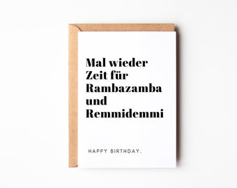 Op de afbeelding: Een witte kaart met zwarte tekst die "Mal wieder Zeit fur Rambazamba und Remmidemmi" en "HAPPY BIRTHDAY." zegt. De kaart is omgeven door een bruine envelop.