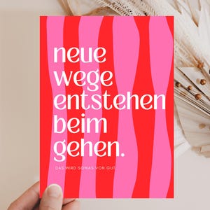 Könnte beinhalten: Rechteckige Grußkarte mit rotem und pinkfarbenem Wellenmuster. Der Text "neue wege entstehen beim gehen" steht in Weiß auf der Karte, mit dem Satz "DAS WIRD SOWAS VON GUT" unten.