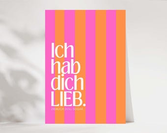 May include: A vertical striped card with alternating pink and orange stripes. The words "Ich hab dich LIEB." are printed in white, with the phrase "ZIEMLICH DOLL SOGAR" below. The card is leaning against a white surface.