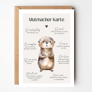 Könnte beinhalten: Eine Grußkarte mit einer Aquarellillustration eines Otters. Die Karte hat deutschen Text und einen braunen Umschlag. Der Text enthält Sätze wie "Du bist großartig" und "Du kannst alles schaffen."