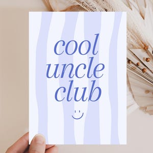 Könnte beinhalten: Rechteckige Karte mit hellblauem, wellenförmigem Streifenhintergrund. Die Worte "cool uncle club" sind in dunkelblauer Schrift geschrieben. Ein Smiley befindet sich unten. Die Karte wird von einer Hand gehalten.