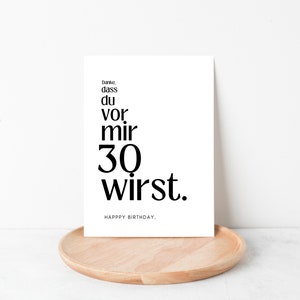 May include: A white card with black text that reads "Danke, dass du vor mir 30 wirst. Happy Birthday."