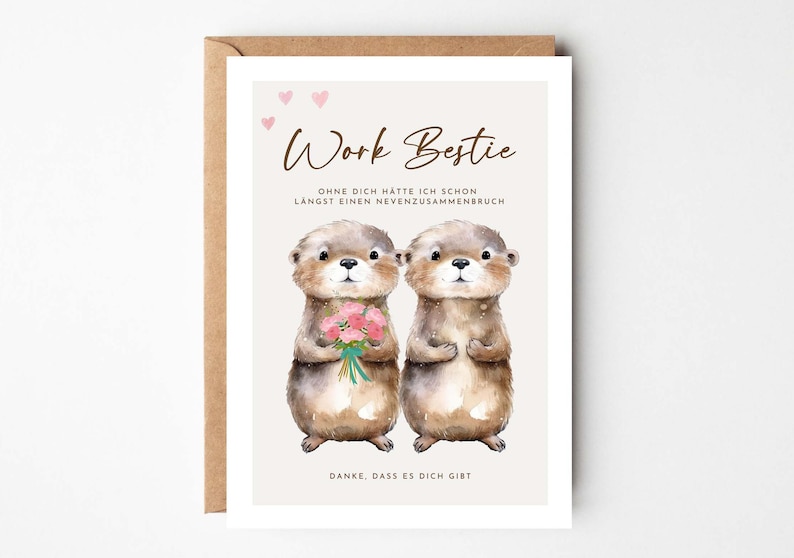 May include: A greeting card with a watercolor illustration of two otters. The card reads "Work Bestie" with text below in German. One otter holds a bouquet of pink flowers. The card is in a brown envelope.