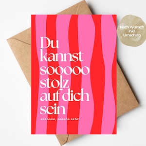 Könnte beinhalten: Eine rechteckige Grußkarte mit vertikalen, wellenförmigen Streifen in abwechselndem Pink und Rot. Die Karte zeigt den weißen Text: Du kannst sooooo stolz auf dich sein, sooooo, sooooo sehr! Sie wird zusammen mit einem braunen Umschlag präsentiert.