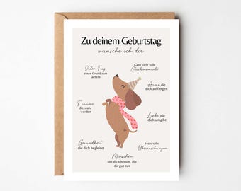 Puede incluir: Una tarjeta de felicitación de cumpleaños con un perro salchicha de dibujos animados con un gorro de fiesta y una bufanda. La tarjeta tiene texto en alemán que desea alegría, salud y amor. La tarjeta está en un sobre marrón.