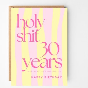 May include: A rectangular greeting card with a vertical wavy striped pattern in pale yellow and light pink. The text in dark pink reads: holy shit 30 years, DON'T PANIC - IT'S JUST LEVEL 3.0, and HAPPY BIRTHDAY. A brown envelope is visible behind the card.