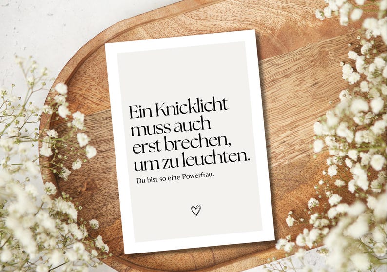 Puede incluir: Una tarjeta blanca con texto negro que dice "Ein Knicklicht muss auch erst brechen, um zu leuchten. Du bist so eine Powerfrau." Hay un peque&ntilde;o s&iacute;mbolo de coraz&oacute;n en la parte inferior de la tarjeta.
