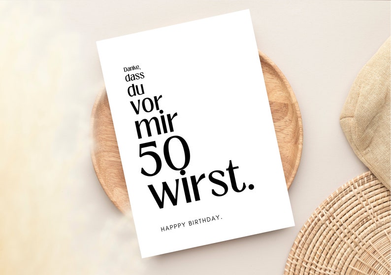 May include: A white card with black text that reads "Danke, dass du vor mir 50 wirst. Happy Birthday."