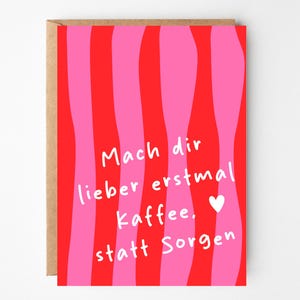 Könnte beinhalten: Grußkarte mit einem wellenförmigen Streifendesign in Rot und Pink. Die Karte zeigt den deutschen Text "Mach dir lieber erstmal kaffee, statt Sorgen" in Weiß, mit einem kleinen weißen Herzen. Die Karte hat einen braunen Rand.