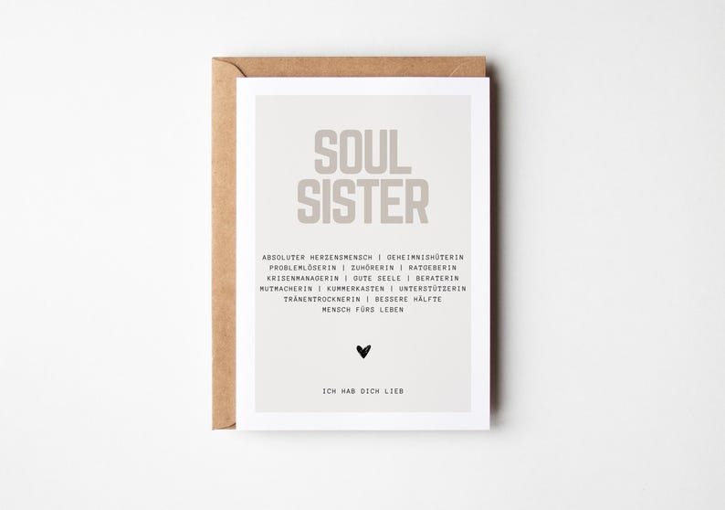 May include: A light gray card with the text "SOUL SISTER" in black. The card has a list of qualities describing a soul sister, including "absolute sweetheart", "secret keeper", "problem solver", "listener", "advisor", "crisis manager", "good soul", "counselor", "encourager", "compassionate", "supporter", "tear dryer", "better half", and "friend for life". The card also has a small black heart and the text "I love you" in black.