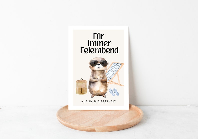 May include: A card with a cartoon otter wearing sunglasses and a backpack. The text on the card reads "F&uuml;r immer Feierabend" and "AUF IN DIE FREIHEIT".