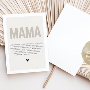 May include: A beige card with the word "MAMA" in large, bold letters. Below the word are a list of positive adjectives describing a mother, such as "protector", "superhero", and "listener". The card is printed on 400g/m2 premium paper and is a DIN A6 postcard.