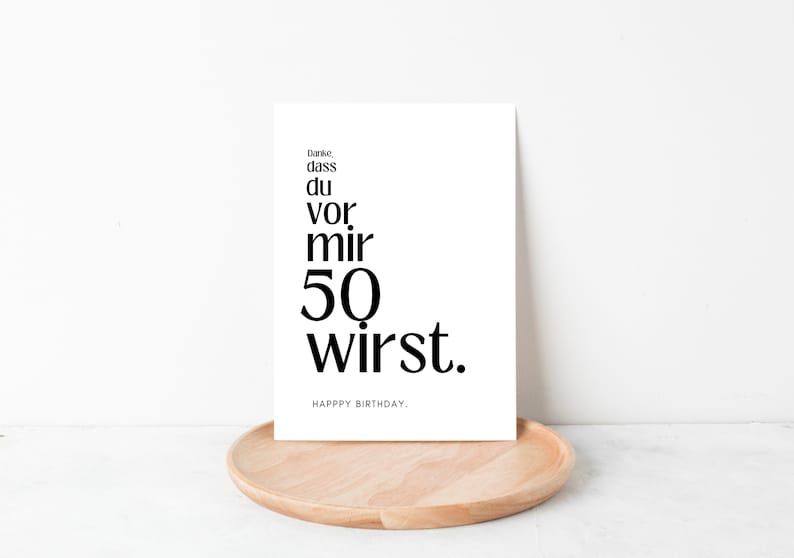 May include: A white card with black text that reads "Danke, dass du vor mir 50 wirst. Happy Birthday."