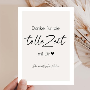 Puede incluir: Tarjeta de felicitación crema con texto en escritura negra. El texto en alemán dice "Danke für die tolle Zeit mit Dir". La tarjeta está sostenida por una mano, con flores secas en el fondo.