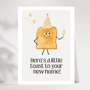 May include: A greeting card featuring a cartoon toast character with a party hat and champagne. The text says, "Here's a little toast to your new home!" The card has a white background and is a housewarming theme.