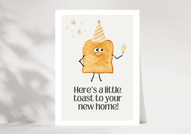 May include: A greeting card featuring a cartoon toast character with a party hat and champagne. The text says, "Here's a little toast to your new home!" The card has a white background and is a housewarming theme.