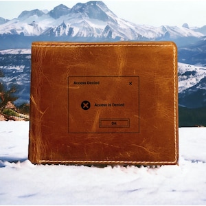 May include: A brown leather wallet with a stitched border. A pop-up window on the wallet reads "Access Denied" with an "X" icon and the text "Access is Denied" and an "OK" button.
